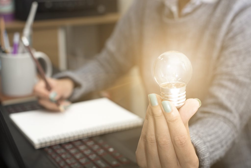 Business women hand holding light bulb, concept of new ideas with innovation and creativity.